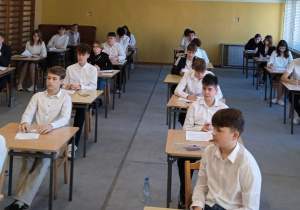 Ósmoklasiści na sali przed rozpoczęciem egzaminu