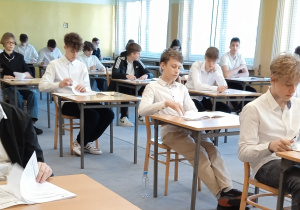 Uczniowie sprawdzają kompletność arkuszy egzaminacyjnych.