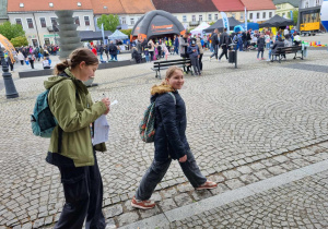 Dziewczynki mierzą, szacują wymiary rynku w Sieradzu.