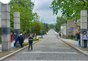 Uczestnicy wyglądają zza Bramy Grodzkiej
