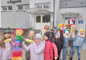 Uczniowie klasy IIIa wychodzą z budynku szkoły wraz z marzannami.