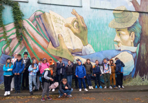 Uczniowie na tle muralu Księżaka z książką