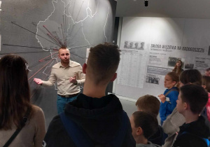 Uczniowie przed mapą pokazująca dokąd wywożono Polaków z Łodzi