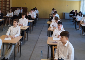 Ósmoklasiści na sali przed rozpoczęciem egzaminu