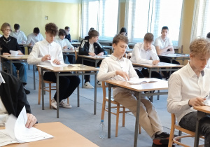 Uczniowie sprawdzają kompletność arkuszy egzaminacyjnych.