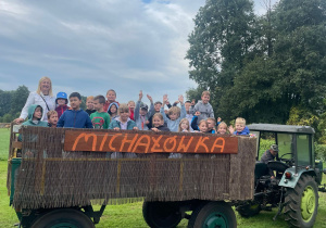 Uczniowie klasy 3 b jadą na przyczepie ciągnika.