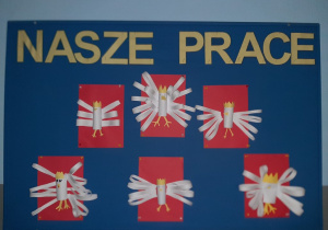 Wystawa prac na tablicy korkowej. Białe orły na czerwonym tle. Wycinanka w formie 3D. Prace wykonane w gr. I pod opieką Pani P. Filipczak.