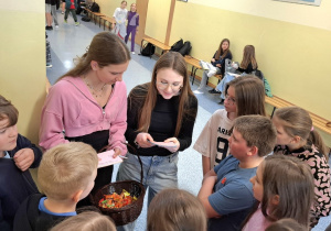 Dziewczynki z klasy 8d zadające pytania młodszym kolegom w czasie przerwy.