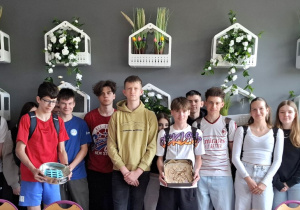 Uczniowie klasy 8d ze słodkościami przypominającymi wiatrak i panele słoneczne.
