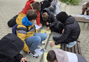 Uczniowie podzieleni na grupy rozwiązują zadania questowe o Janie Karskim