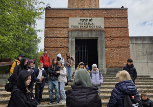 Uczestnicy przed Pomnikiem Pamięci w kształcie złamanej kolumny na Stacji Radegast
