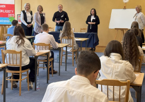 Dyrektor szkoły, wicedyrektor i zespół nadzorujący witają uczniów na egzaminie ósmoklasisty
