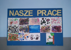 Malowanie farbami. Galeria prac na tablicy korkowej. Malarstwo abstrakcyjne, figury geometryczne, odciśnięte dłonie, kolorowy ptak. Prace wykonane w gr. IV pod opieką Pani M. Nagot.