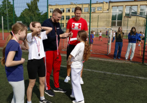 Uroczyste wręczanie medalu po zakończonym biegu dziewcząt.