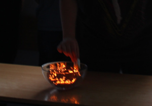 Zdjęcie przedstawia płonącą wełnę aluminiową w szklanej misce