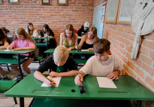 Uczestnicy na lekcji kaligrafii