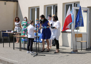 Uczeń klasy III odbiera nagrodę z rąk wychowawcy klasy.