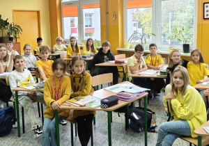 Uczniowie z klasy 4c ubrani na żółto, podczas zajęć z przyrody.