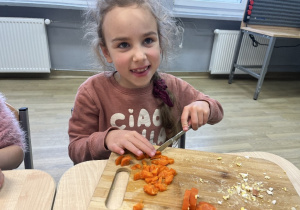 Liwia z wielką radością kroi warzywa do sałatki.