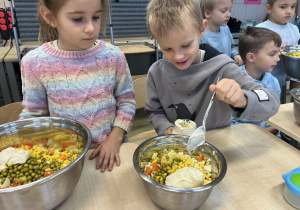 Leon dodaje majonez do sałatki jarzynowej.