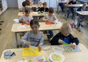 Uczniowie przygotowują sałatkę.