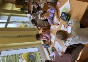 Klasa 1 w sali biblioteki szkolnej, podczas lekcji bibliotecznej.