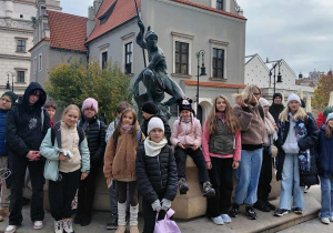 Grupa uczestników przy fontannie Marsa na rynku w Poznaniu