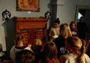 Grupa uczestników wyprawy przed sekretarzykiem z czasów Sienkiewicza