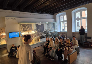 Uczestnicy w Muzeum Literackim Henryka Sienkiewicza słuchają opowieści pani przewodnik