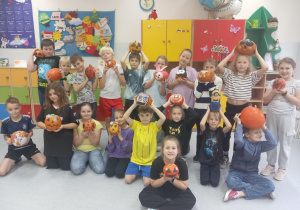 Uczniowie klasy 3 c trzymają w ręce ozdobione dynie.