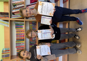 Uczniowie klasy 5 B z dyplomami i nagrodami zdobytymi w zabawie bibliotecznej.