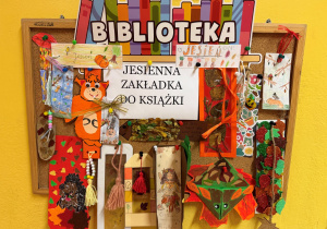Wystawa prac konkursowych na tablicy przed biblioteką szkolną.