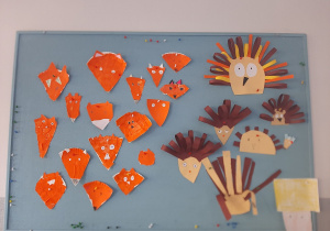 Dekoracja na tablicy korkowej: głowy lisków i jeżyków. Dekoracje wykonane pod opieką Pani P. Filipczak.