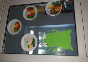 Dekoracja na drzwiach. Duża żaba i pejzaż jesienny wykonany na talerzach papierowych. Dekoracje wykonane pod opieką Pani P. Filipczak.