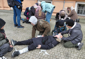 Uczestnicy wyprawy w czasie opatrywania ran nogi głowy i ręki