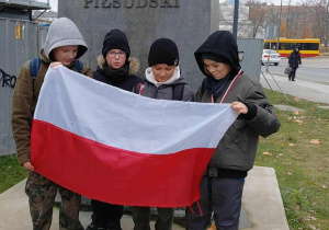 Chłopcy śpiewają jedną z legionowych piosenek trzymając polską flagę