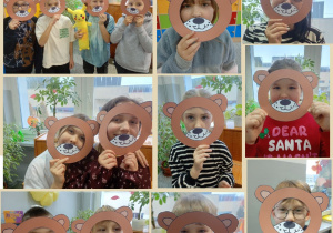 Kilkoro dzieci z klasy pozuje na tle sali lekcyjnej. Na ich twarzach znajdują się papierowe maski misiów.