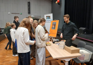 Pisarz Maciej Kaźmierczak rozdaje autografy na spotkaniu autorskim w GOK-u w Rzgowie