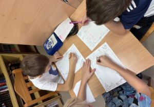 Uczniwoie klasy 3 w trakcie lekcji bibliotecznej dotyczącej lektury "Mikołajek".