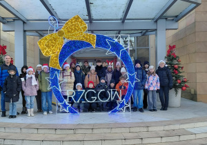 Grupa uczniów przed Urzędem Miejskim przy świątecznej iluminacji