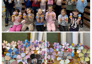 Grupowe zdjęcie uczniów klasy 1b. Dzieci trzymają prezenty dla dziadków.