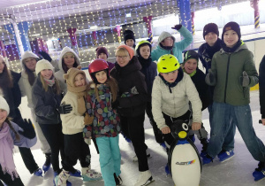 Grupa uczestników zajęć w czasie zabawy na lodzie z opiekunem