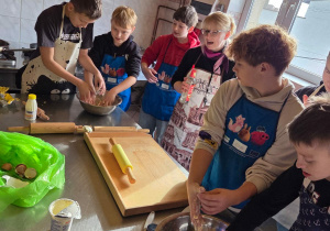 Chłopcy zagniatają ciasto na faworki zgodnie z instrukcjami