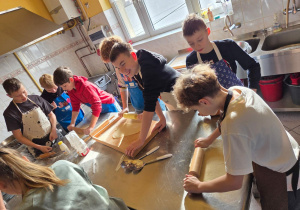 Chłopcy wałkują ciasto na faworki