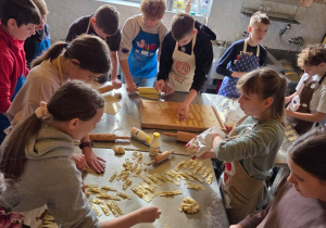 Uczestnicy zajęć kończą pracę przy układaniu faworków