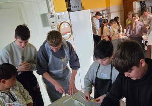 Chłopcy kroją rozwałkowane ciasto