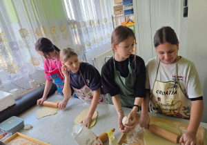 Dziewczyny wałkują ciasto na faworki