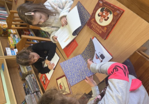 Uczennice klasy pierwszej zapoznają się z fragmentem książki "Wnuczka Antykwariusza".