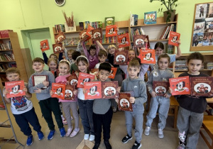 Uczniowie klasy 1 z książką podarowaną przez Instytut książki.