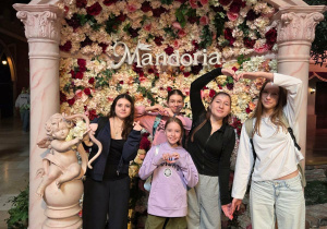 Dziewczynki na tle ścianki z amorkiem z logo Mandorii